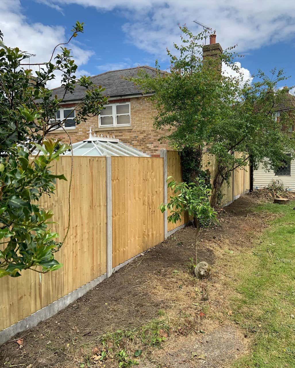 This is a photo of fence panels installed in a residential garden using concrete posts and gravel boards. Installed by Fast Fix Fencing Sutton